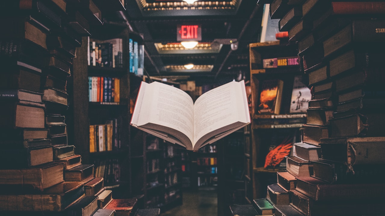 An open dictionary beside a stack of marked-up reading materials